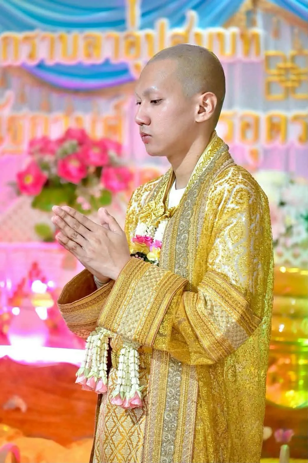 นาคในชุดครุยทองพนมมือ